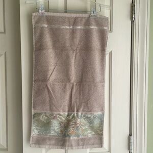 decorative hand towel embroidered at the bottom with floral pattern.